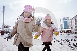 two little girl playing chasing a bird in istanbul taksim photo