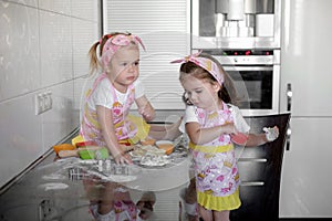 Two Little girl preparing cookies in kitchen at home