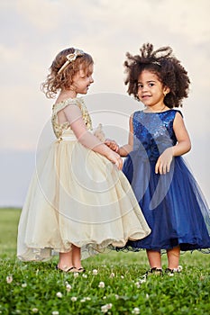 Two little girl in puffy beige and dark-blue gowns photo