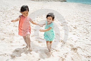 Two little girl running with hold hand enjoy playing together