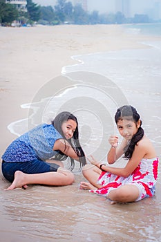 Two little girls are on the beach.