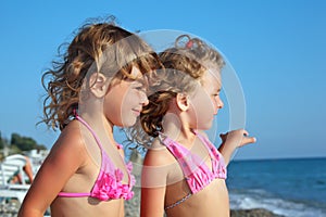 Two little girls on beach, Looking afar