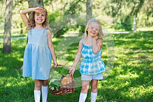 Two little girls carrying basket with organic food