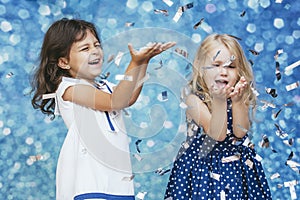 Two little girls child fashion with silver confetti in the background with patches of cute and beautiful