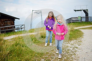 Two little girls enjoying picturesque views from the Tegelberg mountain, a part of Ammergau Alps, located nead Fussen town, German