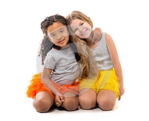 Two little girls-friends with different complexion sitting on the floor