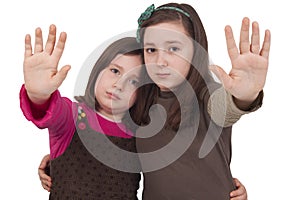 Two little girls gesturing stop