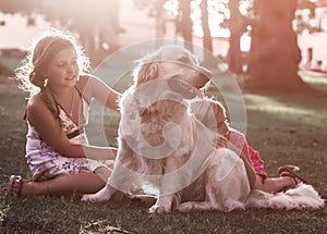 Two little girls with golden retriever dog