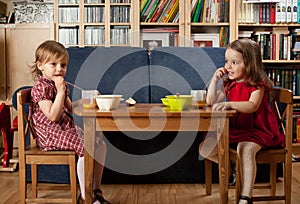 Two little girls have a breakfast at home photo