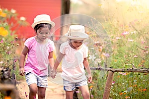 Two little girls holding hand and walking together