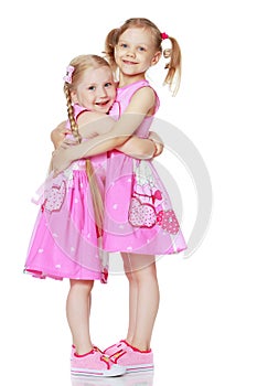 Two little girls hug.