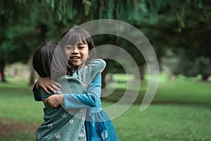 Two little girls hugging each other forgive