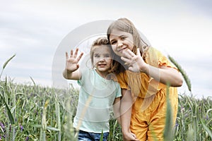 Two little girls hugging each other on a summer field photo