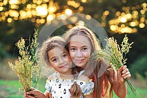 Two  little girls hugging and smiling at the countryside. Happy kids spending time  outdoors