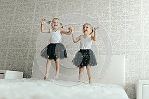 Two Little Girls Jumping on Bed in Snow