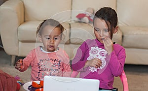 Two little girls with laptop at home