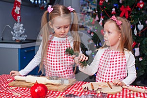 Two little girls make gingerbread cookies for Christmas