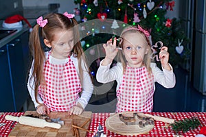 Two little girls make gingerbread cookies for Christmas