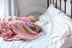 Two little girls napping on a big white bed