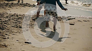 Two little girls play on the beach in summer