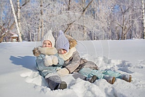 Two little girls play and hug each other in a winter