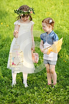 Two little girls play with net and butterflies in
