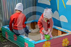 Two little girls play in the sandbox