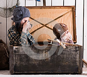 Two little girls playing in big wooden chest with old camera