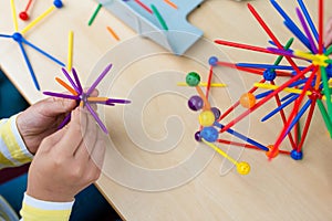 Two little girls playing with lots of colorful plastic sticks kit indoors. kids having fun with building geometric figures and l