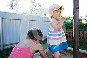 Two little girls playing in sandbox. summer activity for children