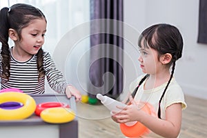 Two little girls playing small toy balls in home together. Education and Happiness lifestyle concept. Funny learning and Children