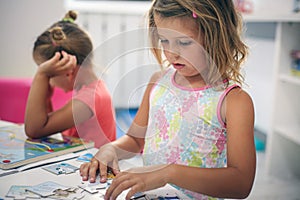 Two little girls playing together in playground.