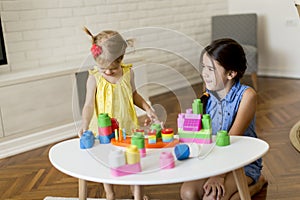 Two little girls playing with toys in the room