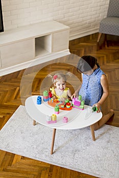 Two little girls playing with toys in the room