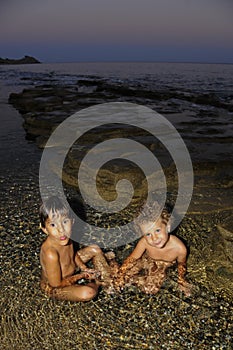 Two little girls playing in water at seaside