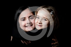 Two little girls posing on a black background