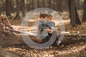 Two little girls reading books in the woods
