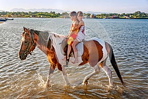 Two little girls riding horse in the summer in Ada Bojana, Monte photo