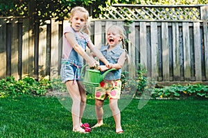 Two little girls sisters having fight on home backyard