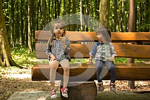 Two little girls sit on the bench