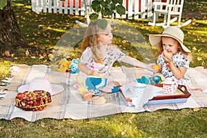 Two little girls sitting on green grass