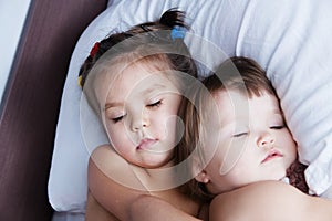 Two little girls sleeping lying on bed. sibling sleep schedule in domestic lifestyle. sisters togetherness