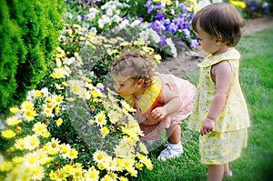 Two Little Girls Smelling Spring Flowers