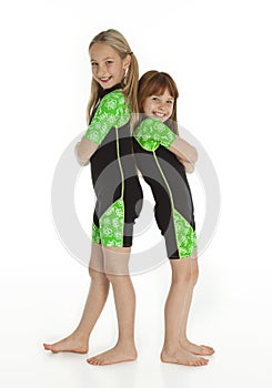 Two Little Girls Standing Back to Back Wearing Wetsuits