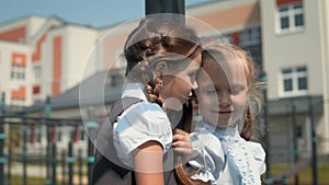 Two little girls talking at schoolyard