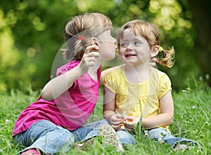 Two little girls telling secrets photo
