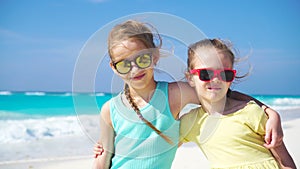 Two little girls together on the beach on caribbean vacation. Portrait of two kids outdoors