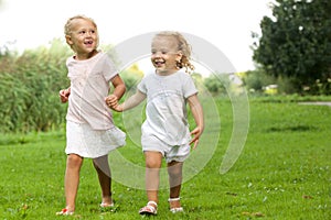 Two little girls walking in the park