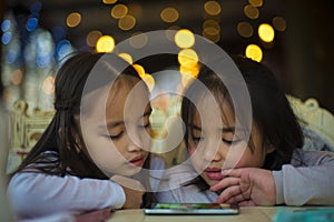 Two little girls watching a video on mobile phone
