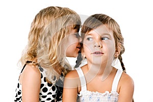 Two little girls whispering isolated over white
